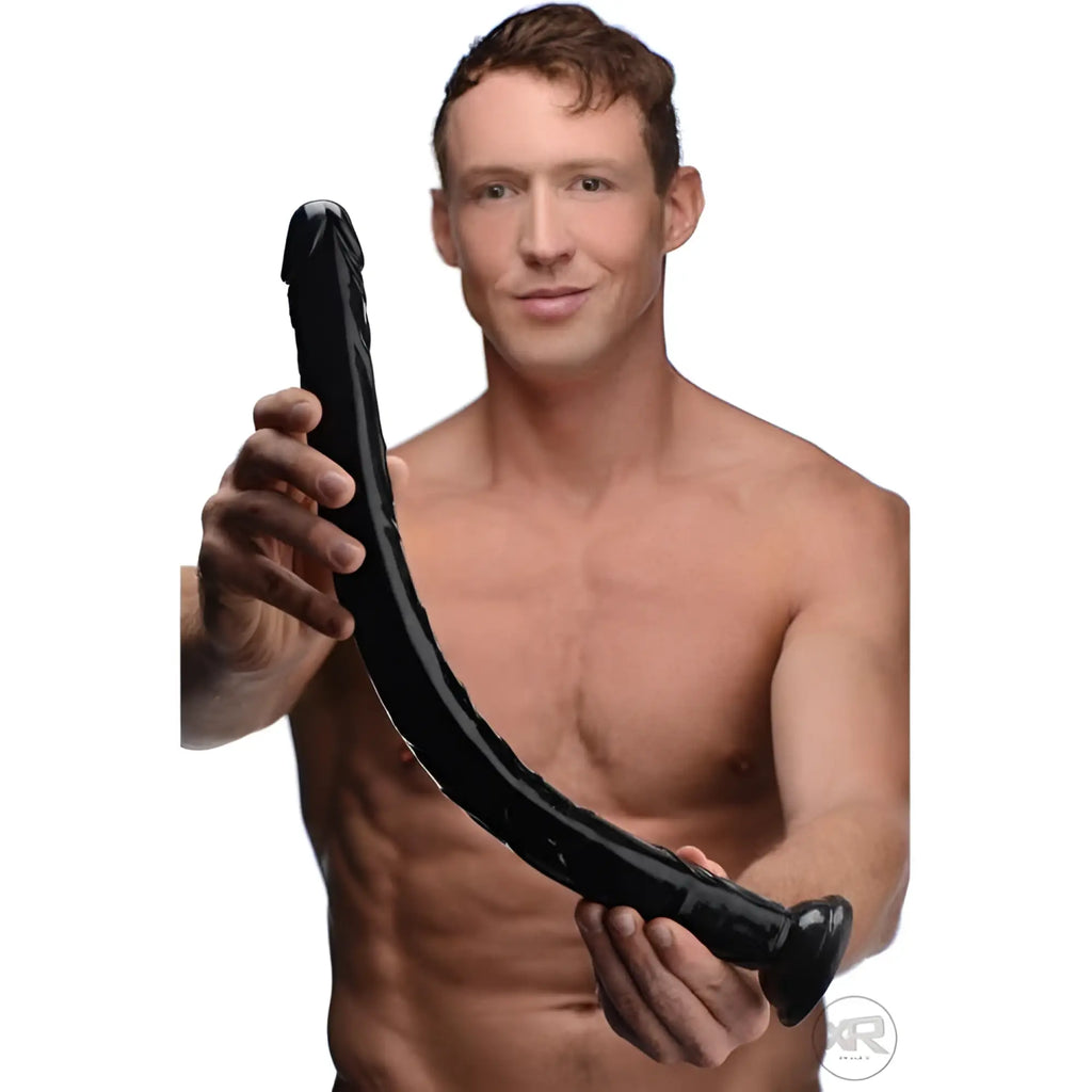 A shirtless man holds a long, black, realistic Hosed 19-inch anal dildo with a curved, textured design.
