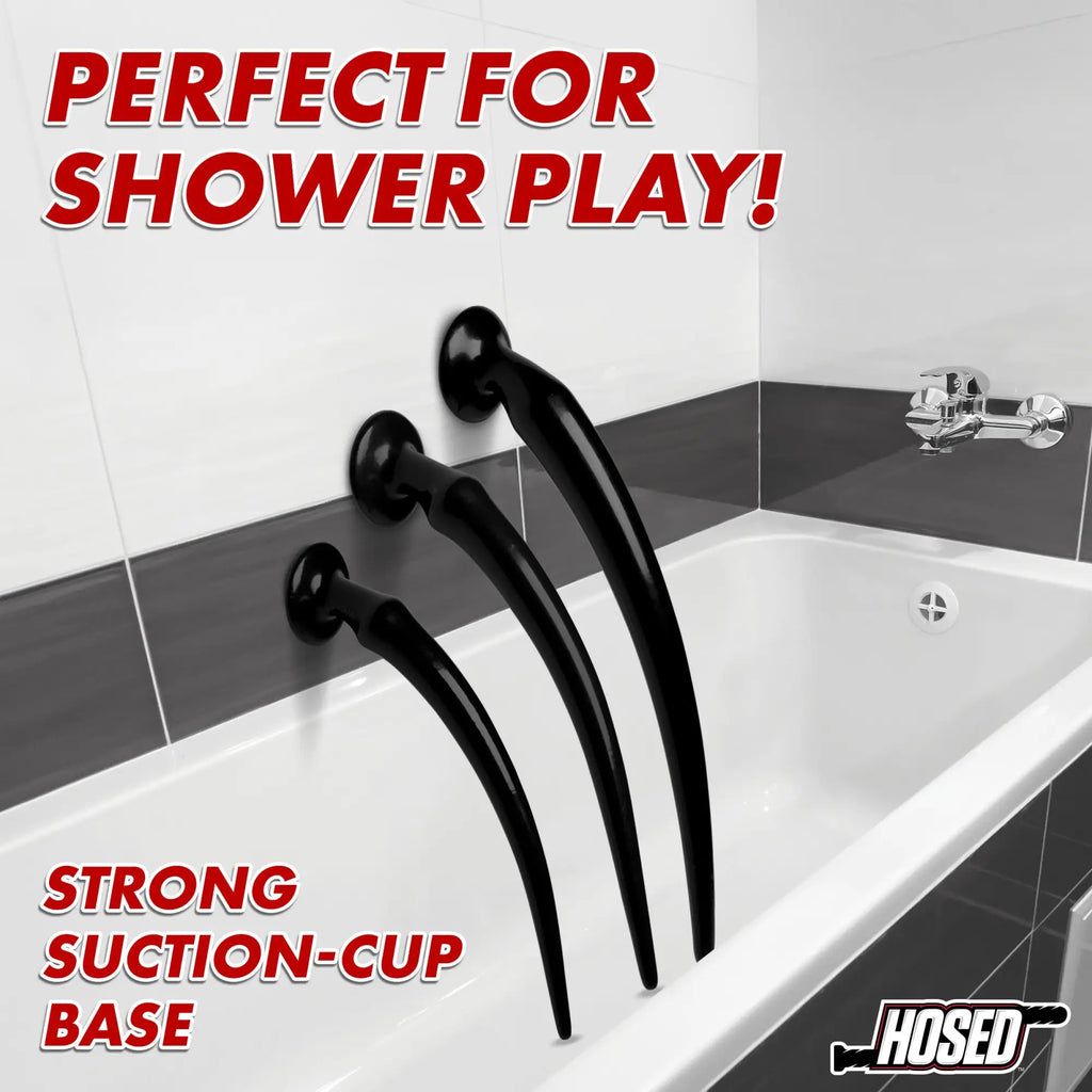 Hosed Slim Tapered Anal Hose Training Set: Three black, tapered toys with suction-cup bases attached to a tiled wall.