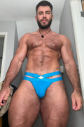 Bright blue hustler cross briefs with strappy design and white diamond-shaped accent at the front