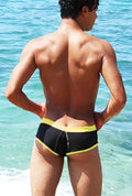Black swim trunks with bright yellow trim featuring contrast stitching for cheeky bikini swimwear use