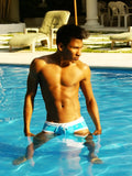A man standing in a pool wearing icker sea cord contrast trim and stitching bikini swimwear in blue and white