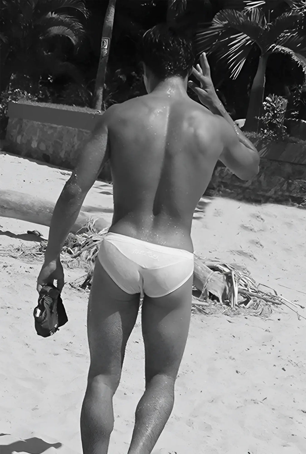 A man wearing icker sea duotone bikini swimwear red white briefs on a beach showing front side