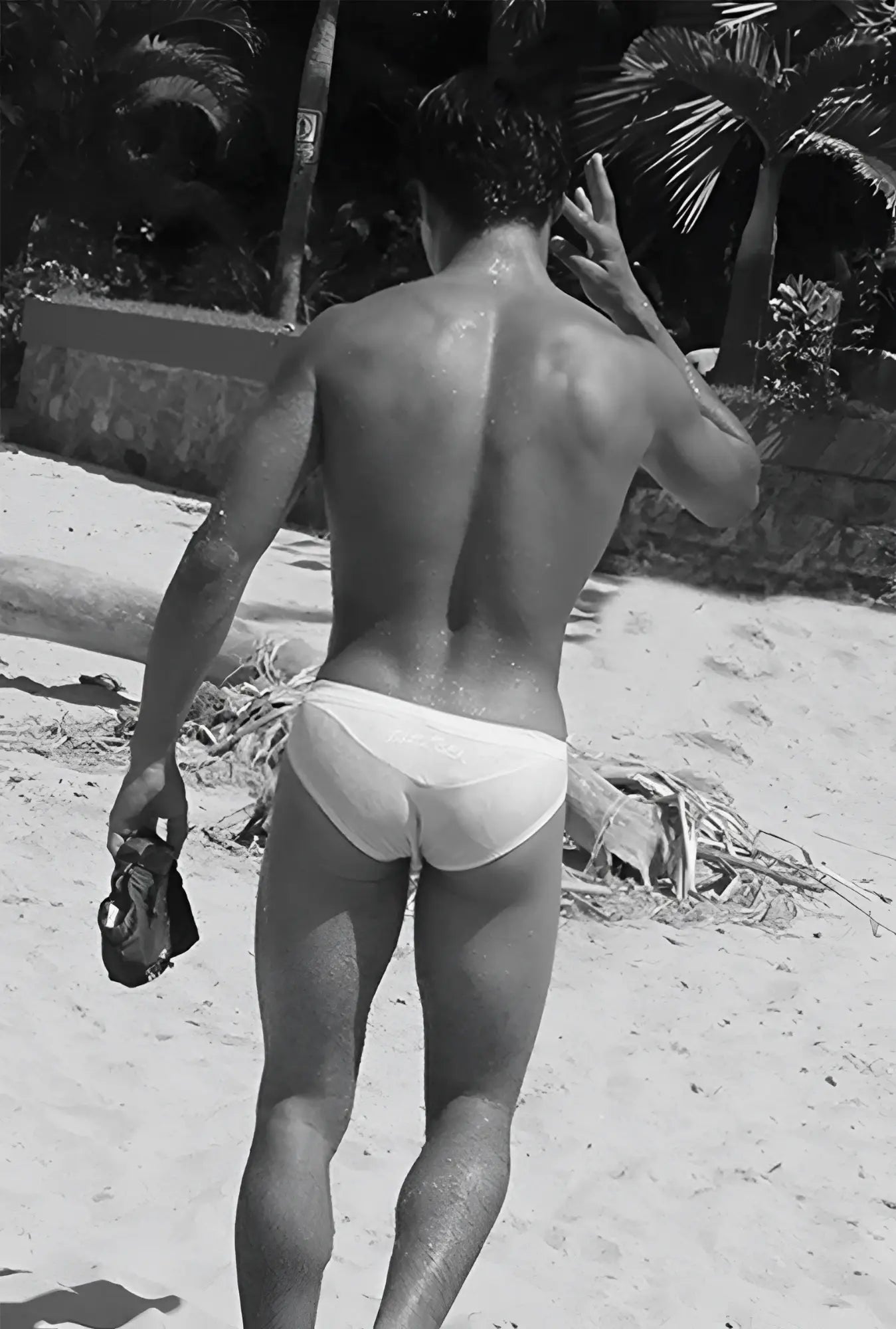 A man wearing icker sea duotone bikini swimwear red white briefs on a beach showing front side