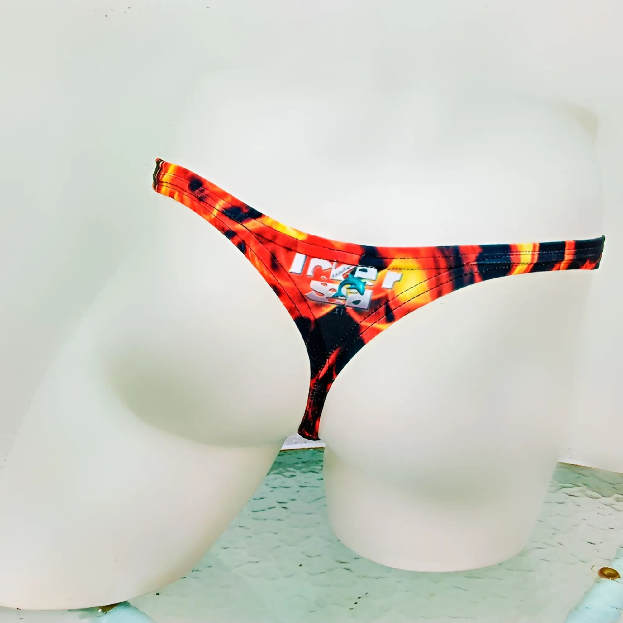 Vibrant orange and black flame-patterned thong underwear with ice logo patch from icker sea fire red collection