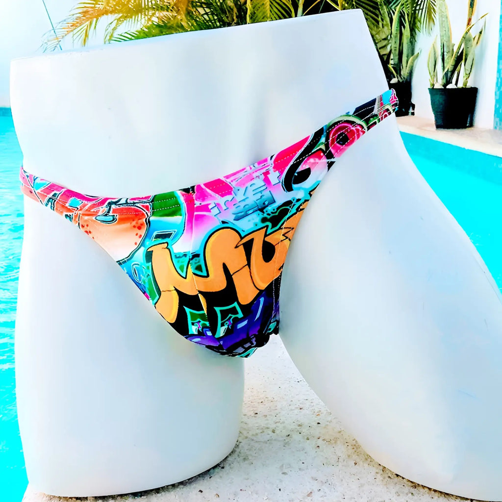 Icker Sea graffiti thong swimwear in vibrant graffiti pattern with bold pink orange teal and purple hues