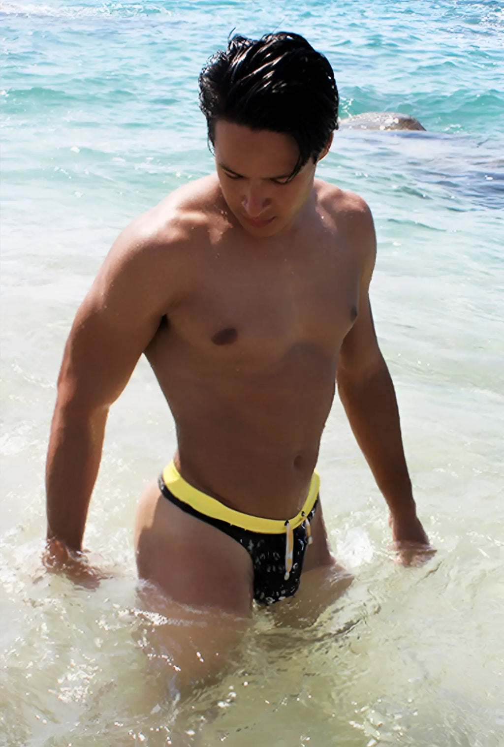 Icker Sea Letters thong swimwear black with bold yellow waistband and white drawstring swim trunks front view