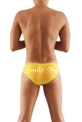 Bright yellow Icker Sea Smile Me slip bikini underwear with white cursive script front for swimwear and beachwear