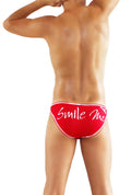 Red swim trunks with white smile me cursive text and thin white trim from icker sea slip bikini underwear collection