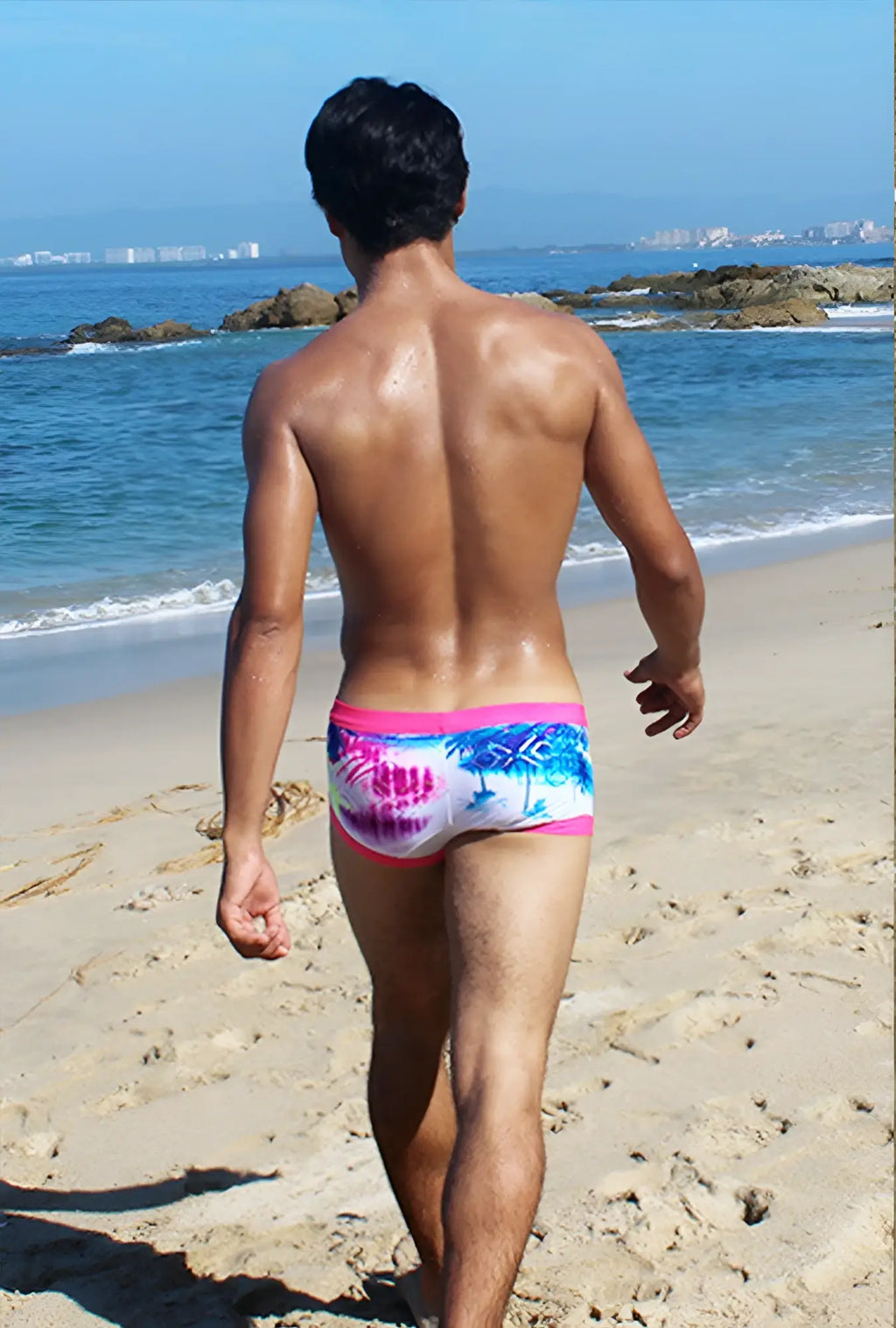 Icker Sea spring square cut swim trunks with pink waistband and blue palm tree pattern on white background