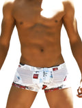 White men’s swim trunks by icker sea toys with vibrant tropical print in red black and blue for casual beachwear
