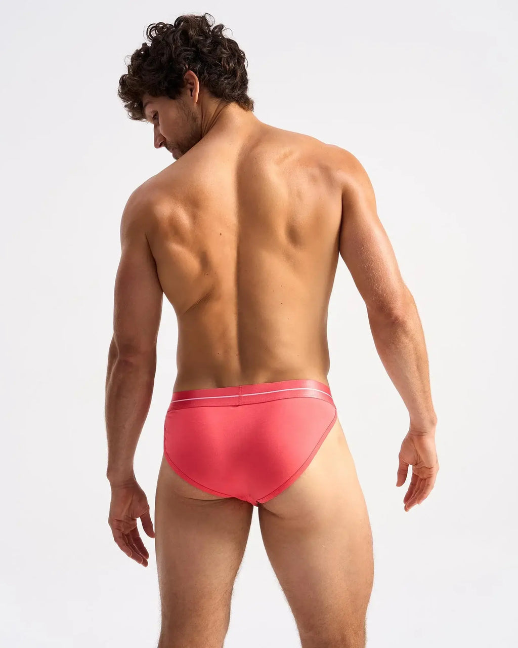 A vibrant coral icon sports brief with sleek smooth fabric and subtle white trim along the waistband