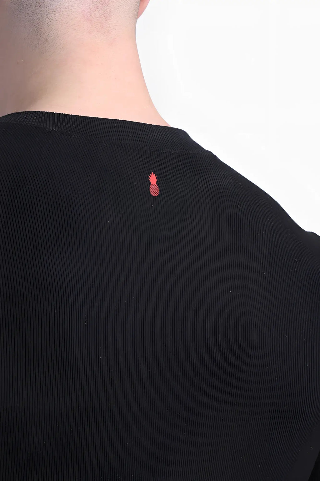 Back view of infinity long sleeve button up bodysuit in midnight black black corduroy with small red pineapple logo