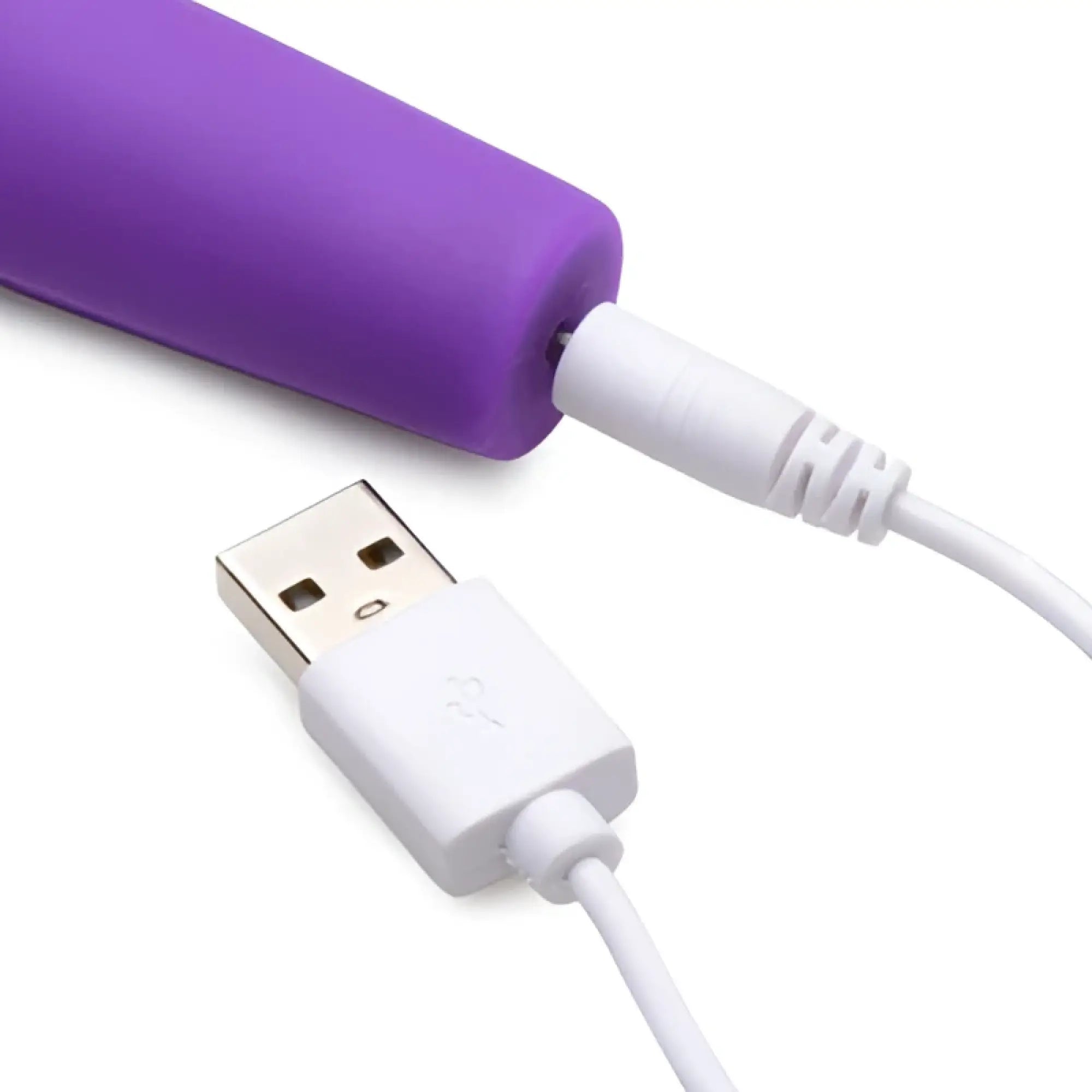 Inmi 10X En Pointe purple silicone teaser shown charging with its white USB magnetic cable against a white background.