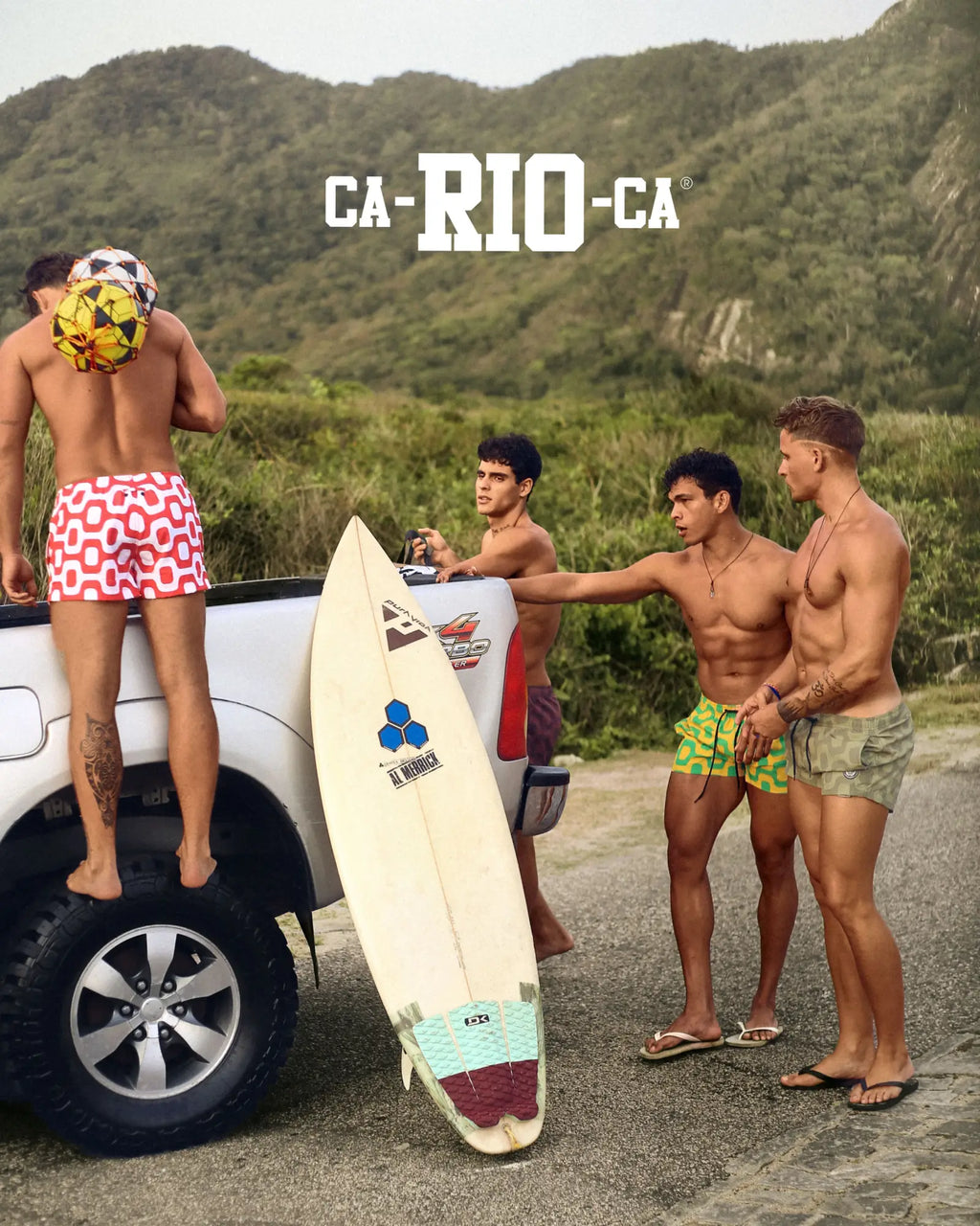 White surfboard with teal and maroon traction pad and blue triangular logo featured with ipanema pavement italian shorts
