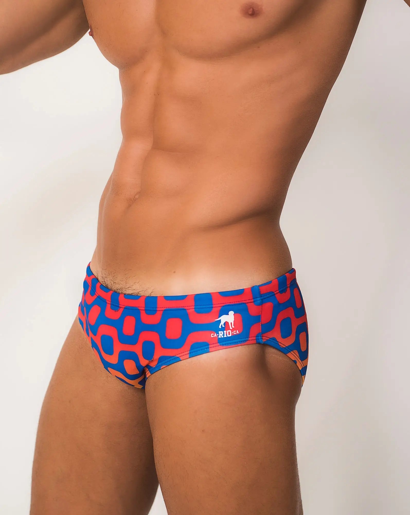 Ipanema Sunga men’s designer swimwear featuring blue and red geometric patterned swim trunks with white dog logo