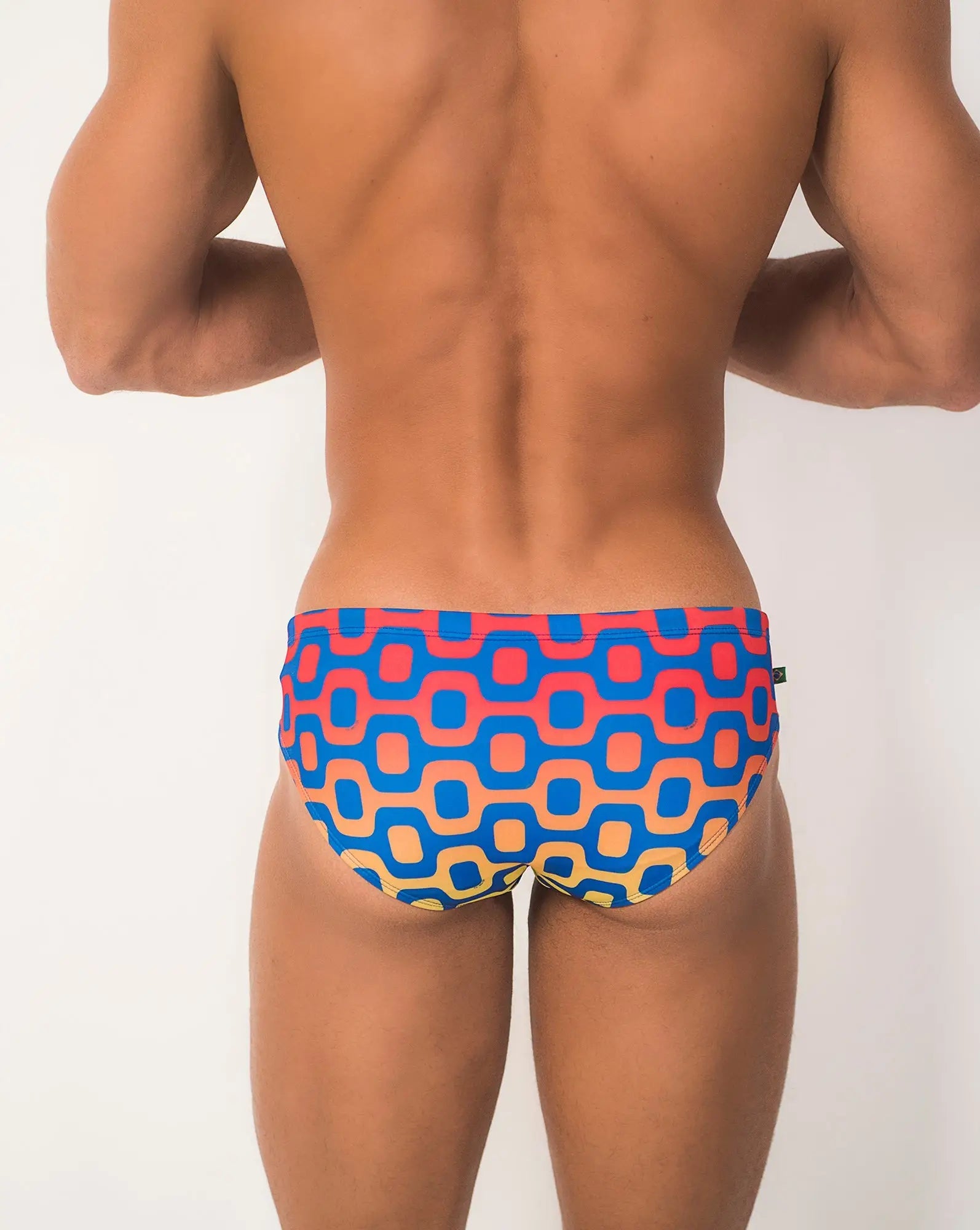 Ipanema sunga men’s designer swimwear featuring vibrant geometric-patterned swim trunks in blue coral pink and beige tones