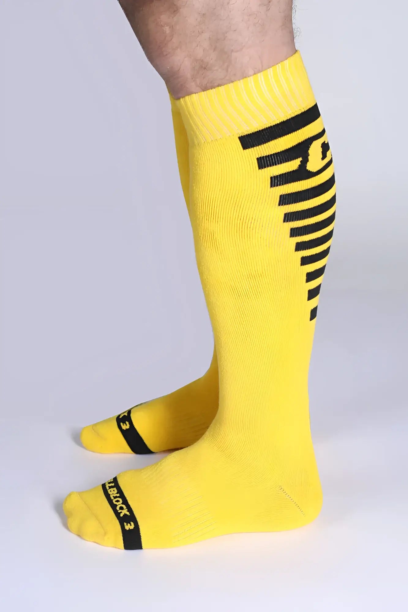 Iron grip knee high sock in bright yellow with bold black stripes and reinforced toe caps for durability