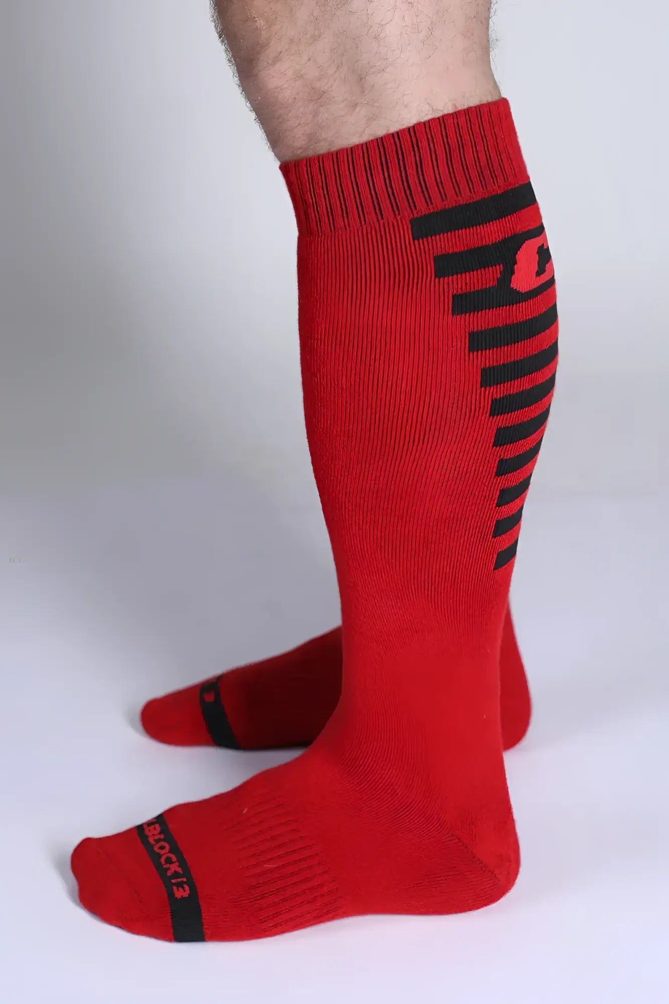 Iron grip knee high sock in red with black horizontal stripes and a side logo designed for athletic support