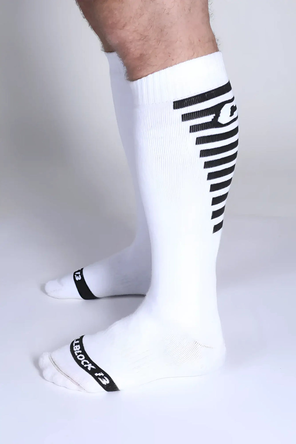 Iron Grip knee high socks in white with black diagonal stripes and tiblock 13 branding near the toe