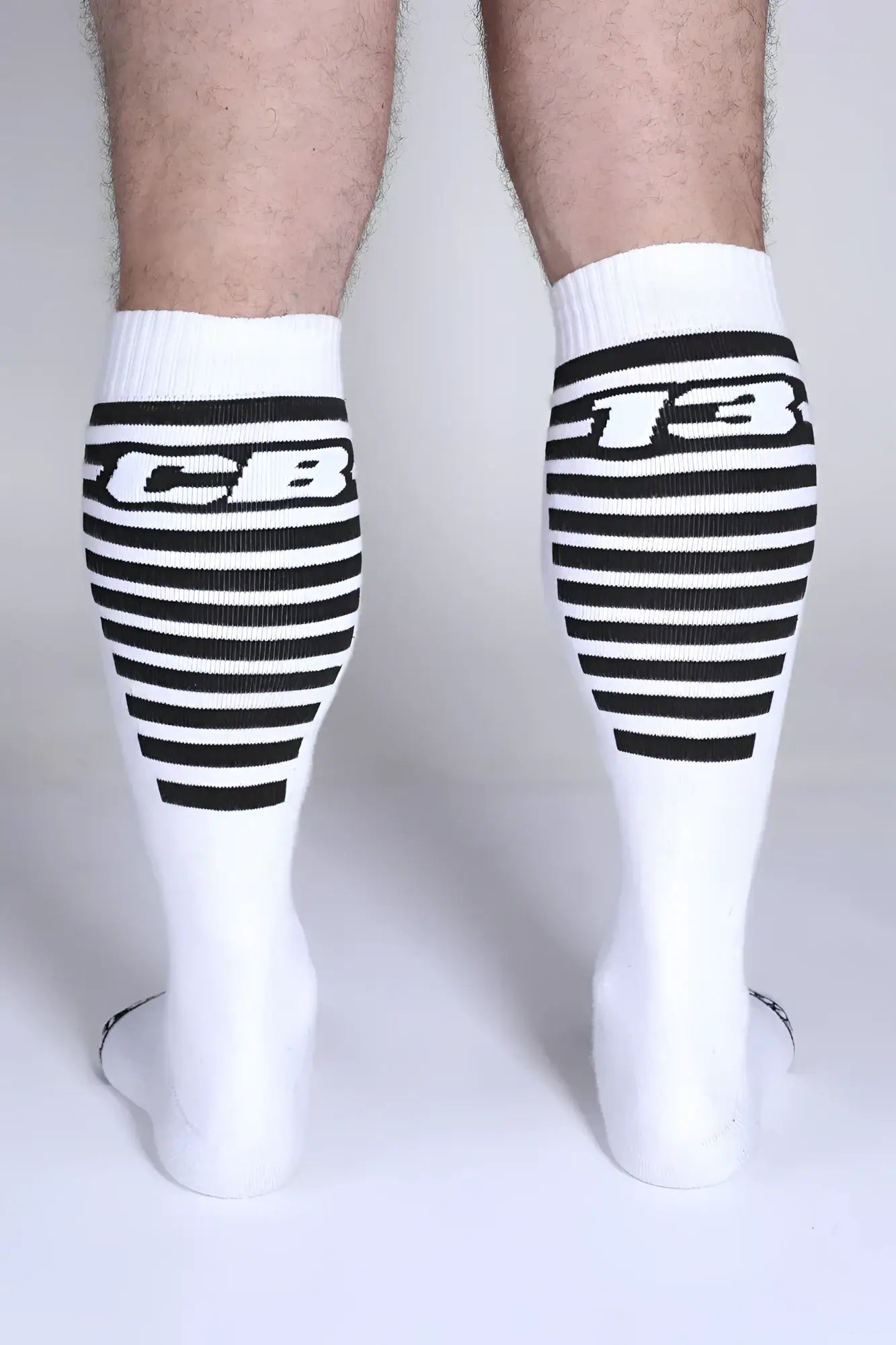 White iron grip knee high socks with black horizontal stripes and bold cb or 13 lettering on the upper leg