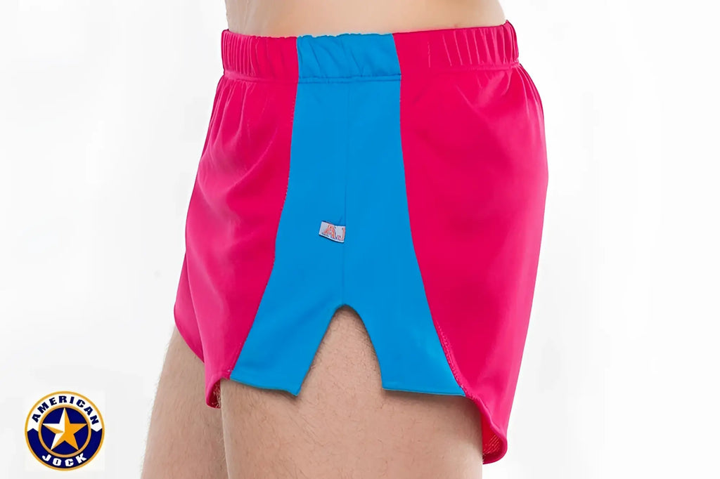 A j javelin field short featuring bright pink and blue color-block athletic shorts with elastic waistband and brand tag