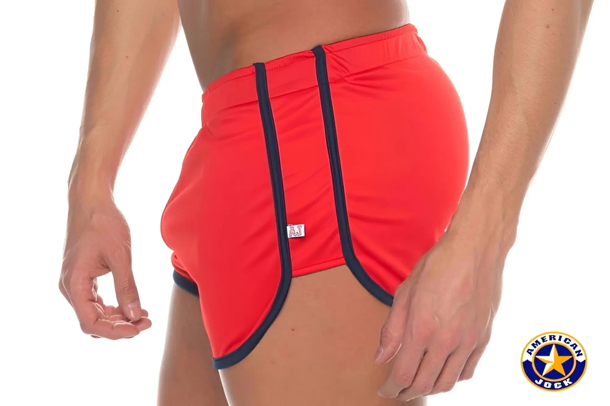 Red A J Phys Ed track shorts with navy blue trim and a small white brand tag for athletic use