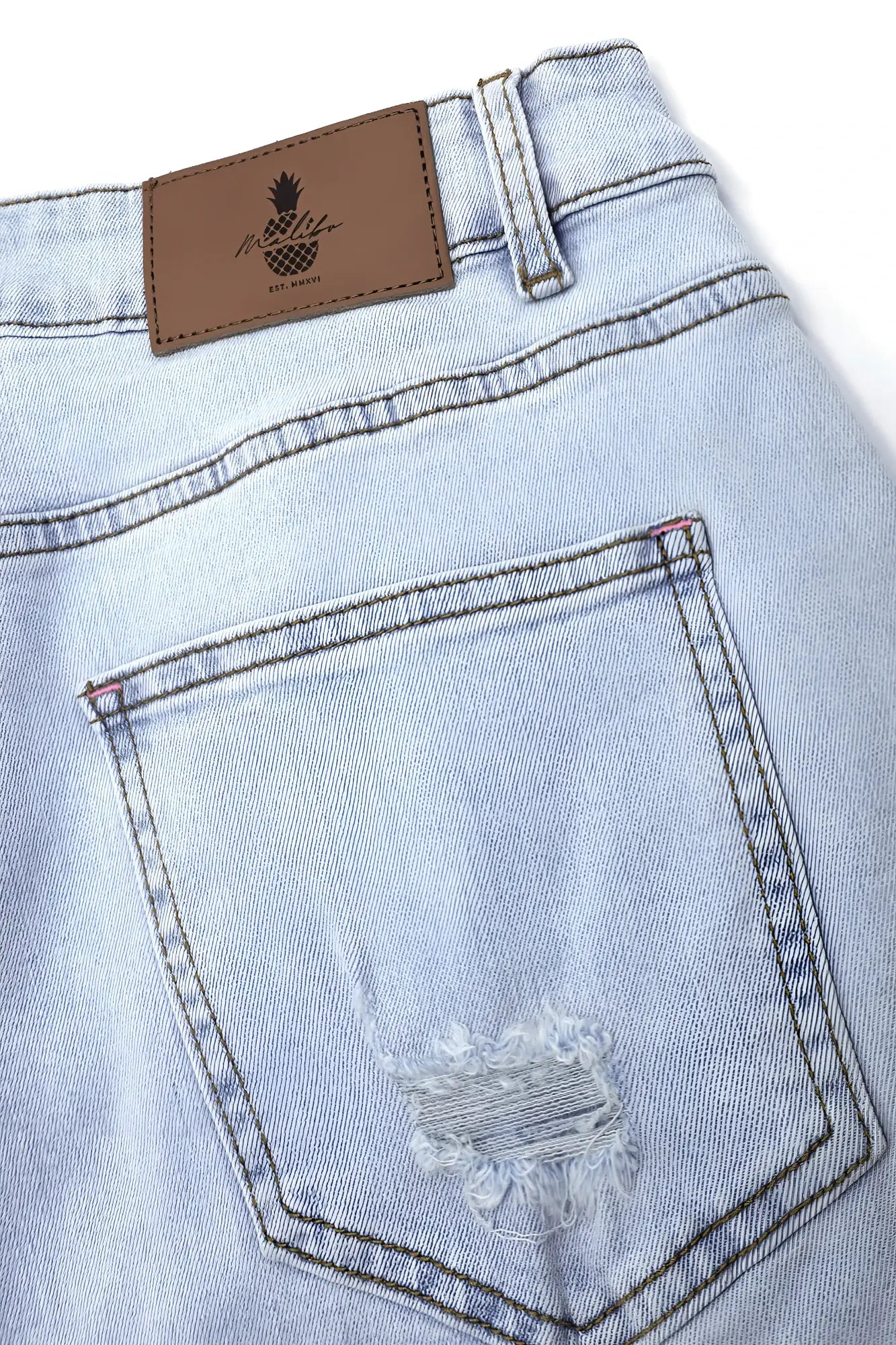Back side of light sky blue jaded 3.5 inch denim short shorts with distressed back pocket and brown leather pineapple label