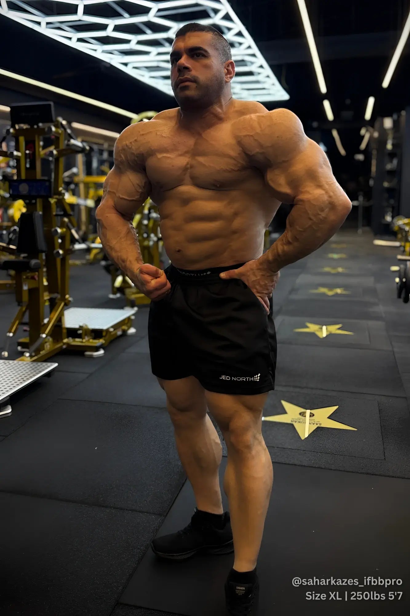 A muscular man wearing jed north 5 inch double layer mesh basketball shorts in black with xl size label