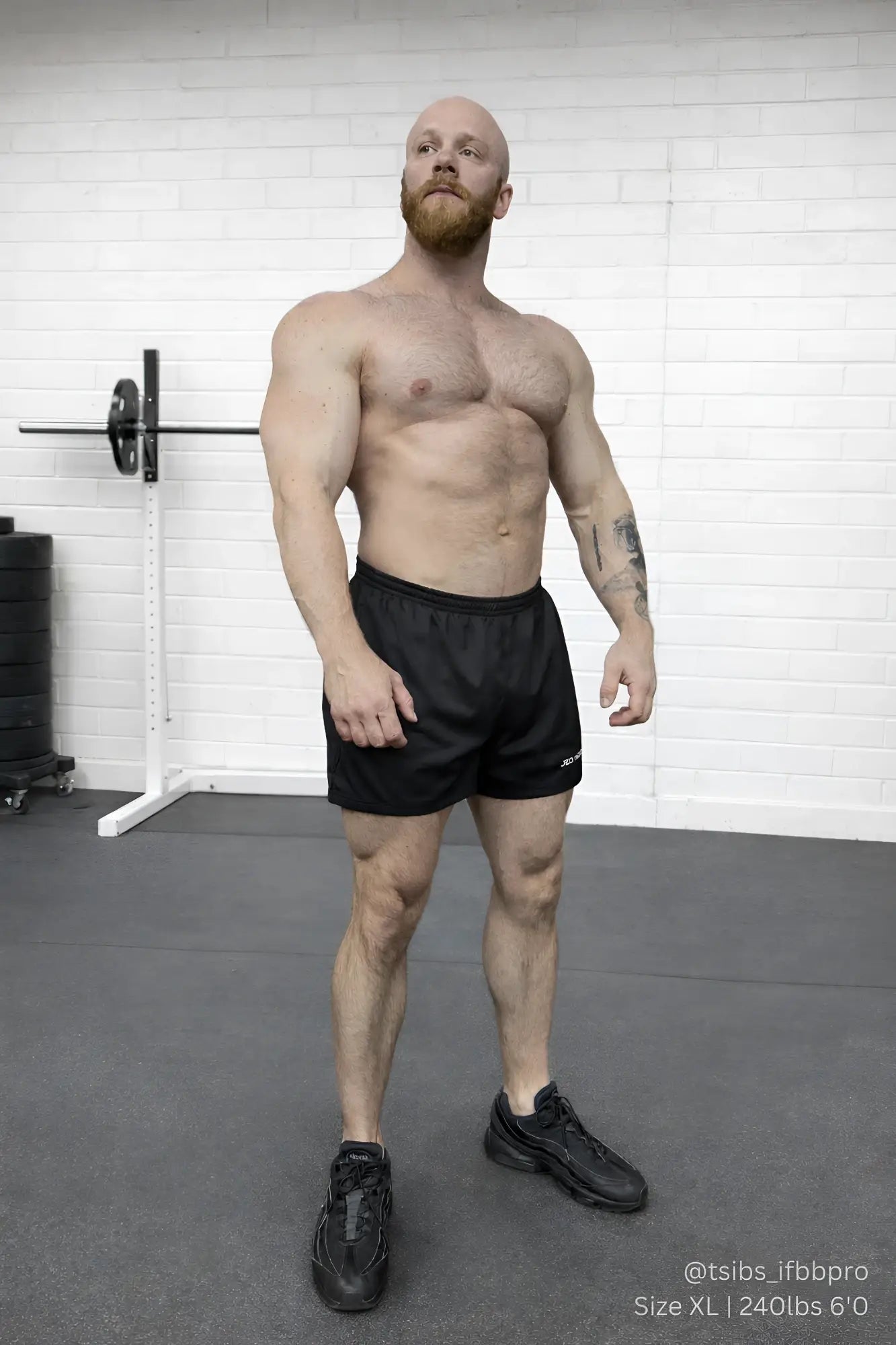 A muscular man with a red beard wearing black 5 inch double layer mesh basketball shorts showcasing his defined physique