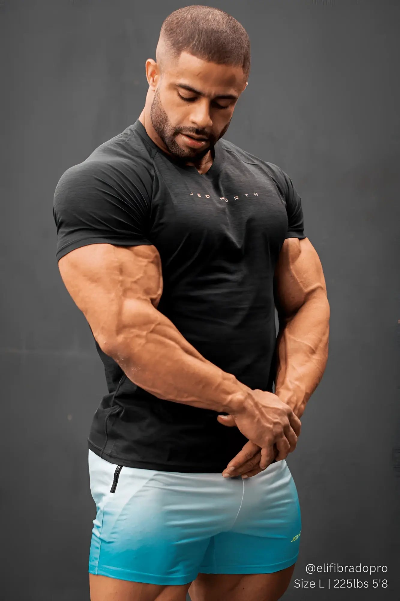 Black short-sleeved t-shirt with red worth text paired with jed north agile bodybuilding blue ombre 4 inch shorts with zipper pockets