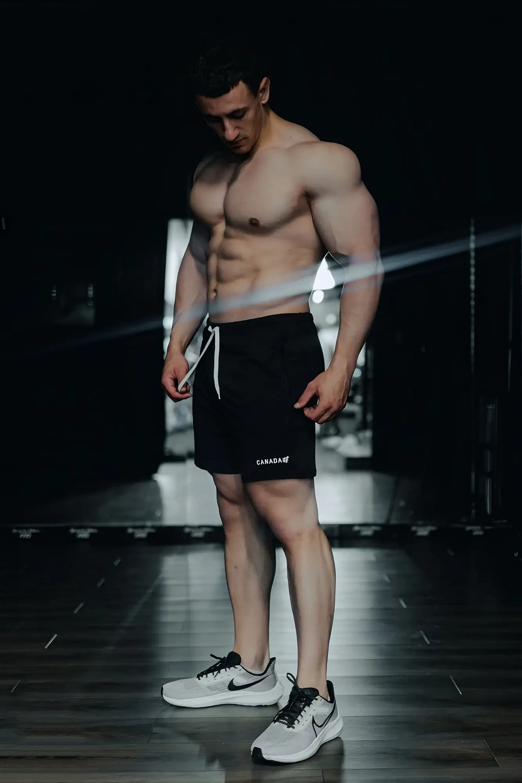 Black agile bodybuilding 4 inch shorts with white drawstring zipper pockets and canada logo on lower left leg