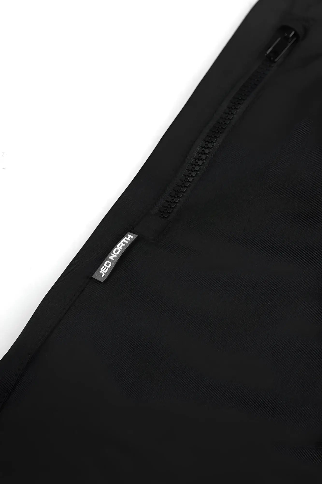 Black zippered pant leg of agile bodybuilding 4 inch shorts with zipper pockets featuring canada logo and matte texture