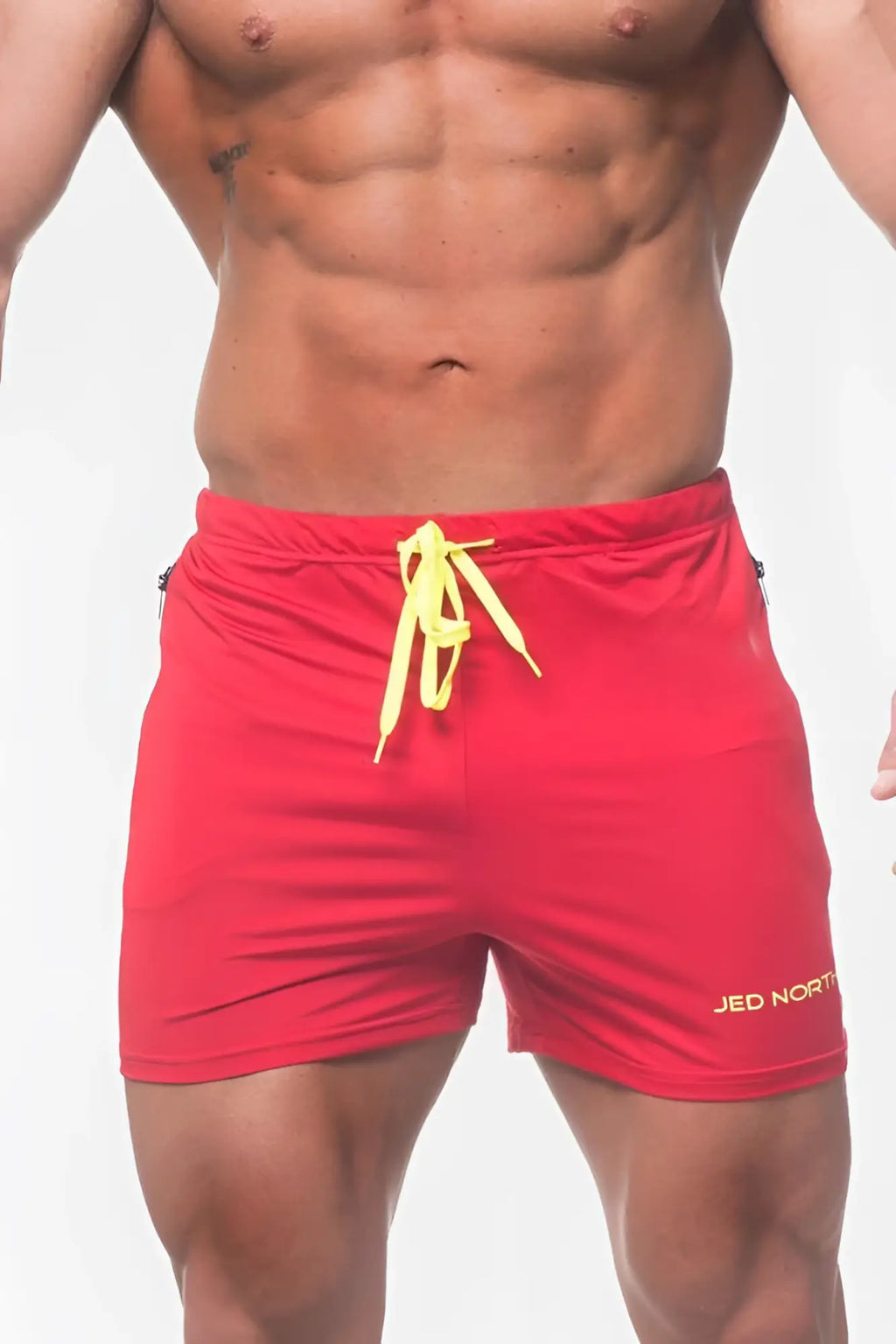 Red jed north agile bodybuilding 4 inch shorts with bright yellow drawstring and gold logo on lower right leg