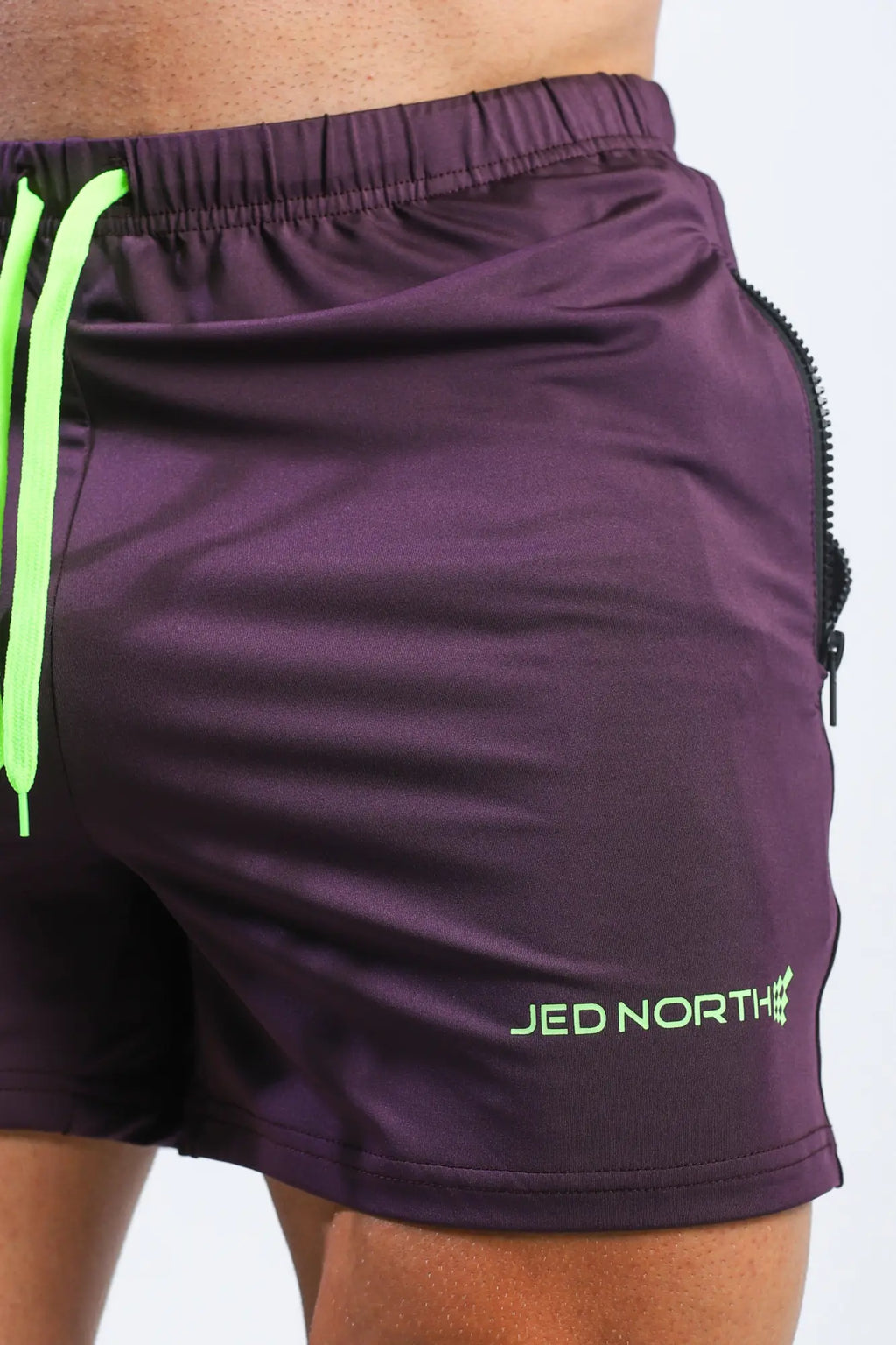 Purple jed north agile bodybuilding 4 inch shorts with neon green drawstrings and zipper pockets for workout use