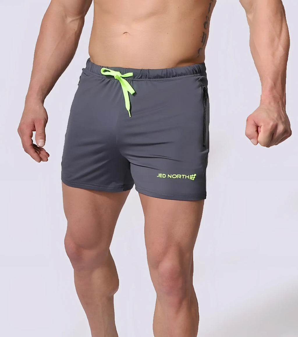 Gray jed north agile bodybuilding 4 inch shorts with neon green drawstring and side zipper pockets visible on lower leg