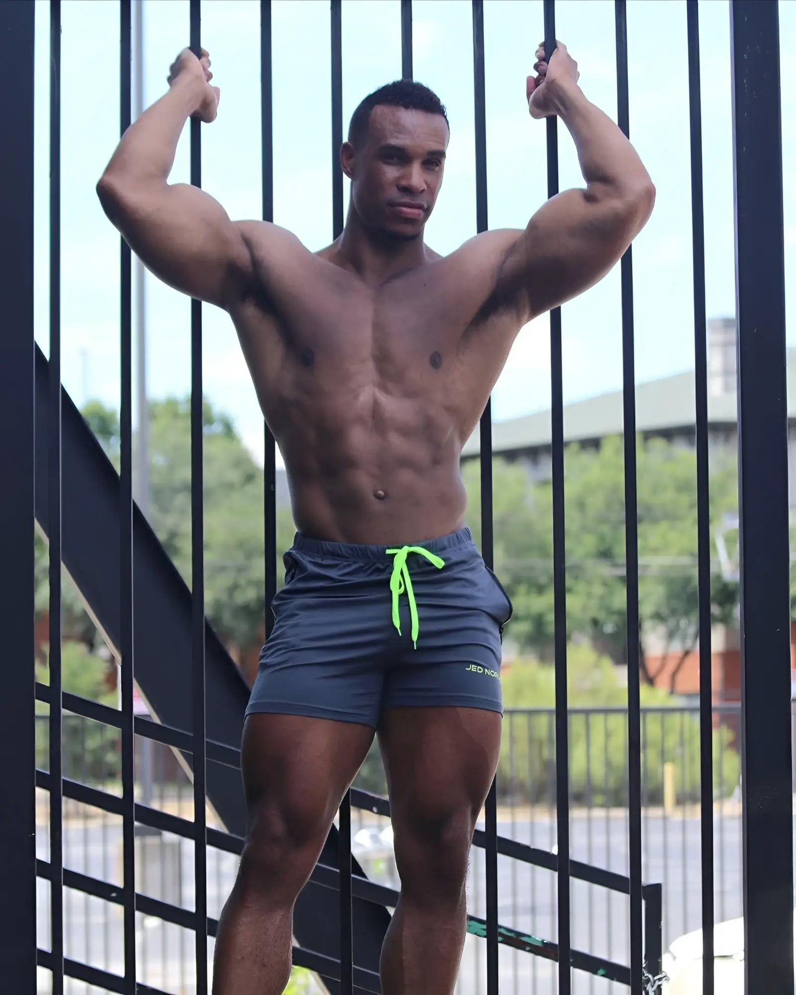 Dark gray jed north agile bodybuilding shorts with neon green drawstring zipper pockets and small logo on lower right leg