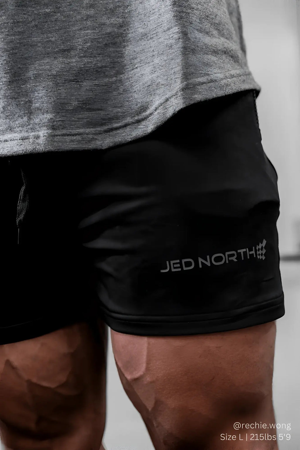 Black jed north agile bodybuilding 4 inch shorts with zipper pockets and gray logo embroidered on lower right leg