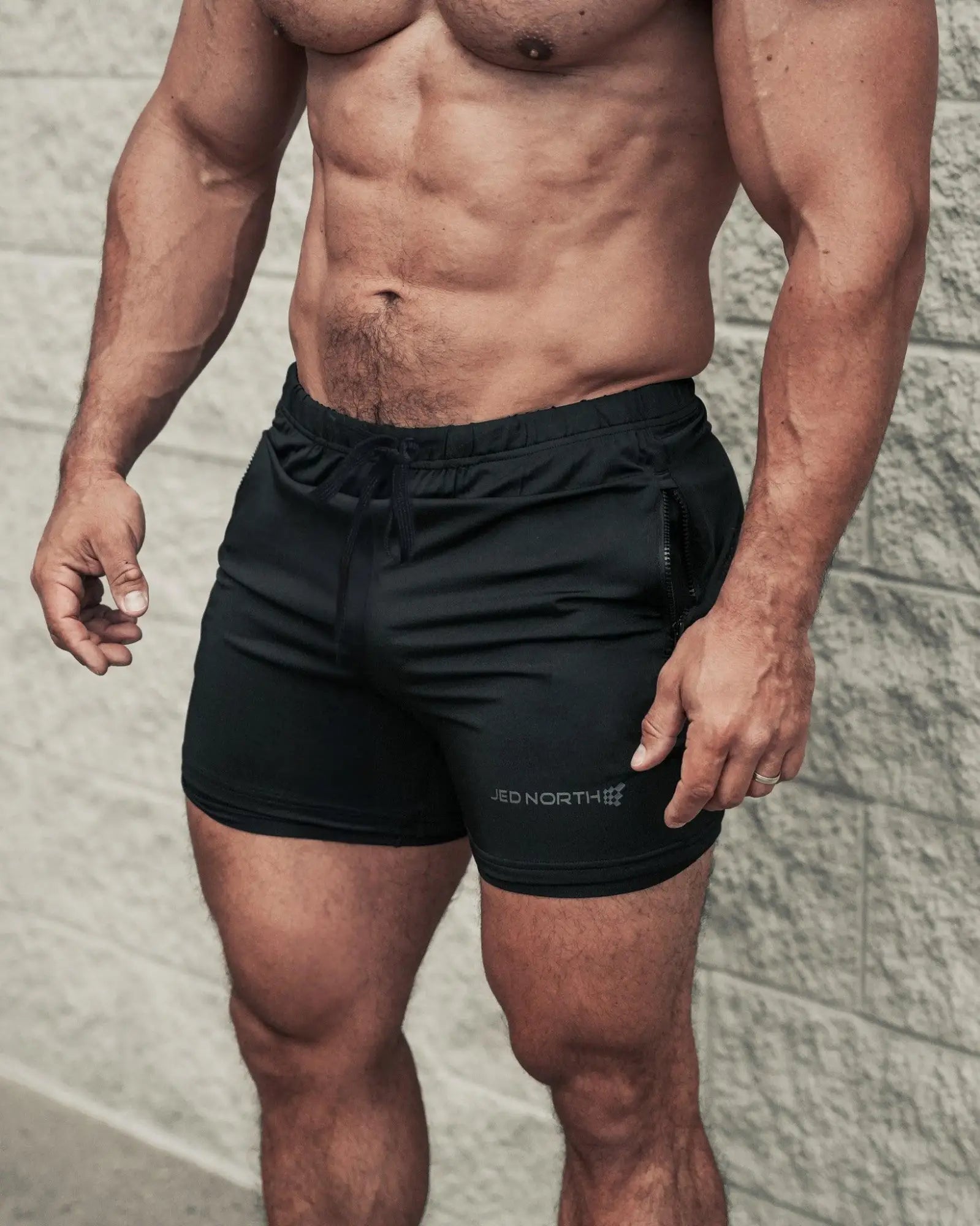 Black jed north agile bodybuilding 4 inch shorts with drawstring waistband, zipper pockets, and red north logo