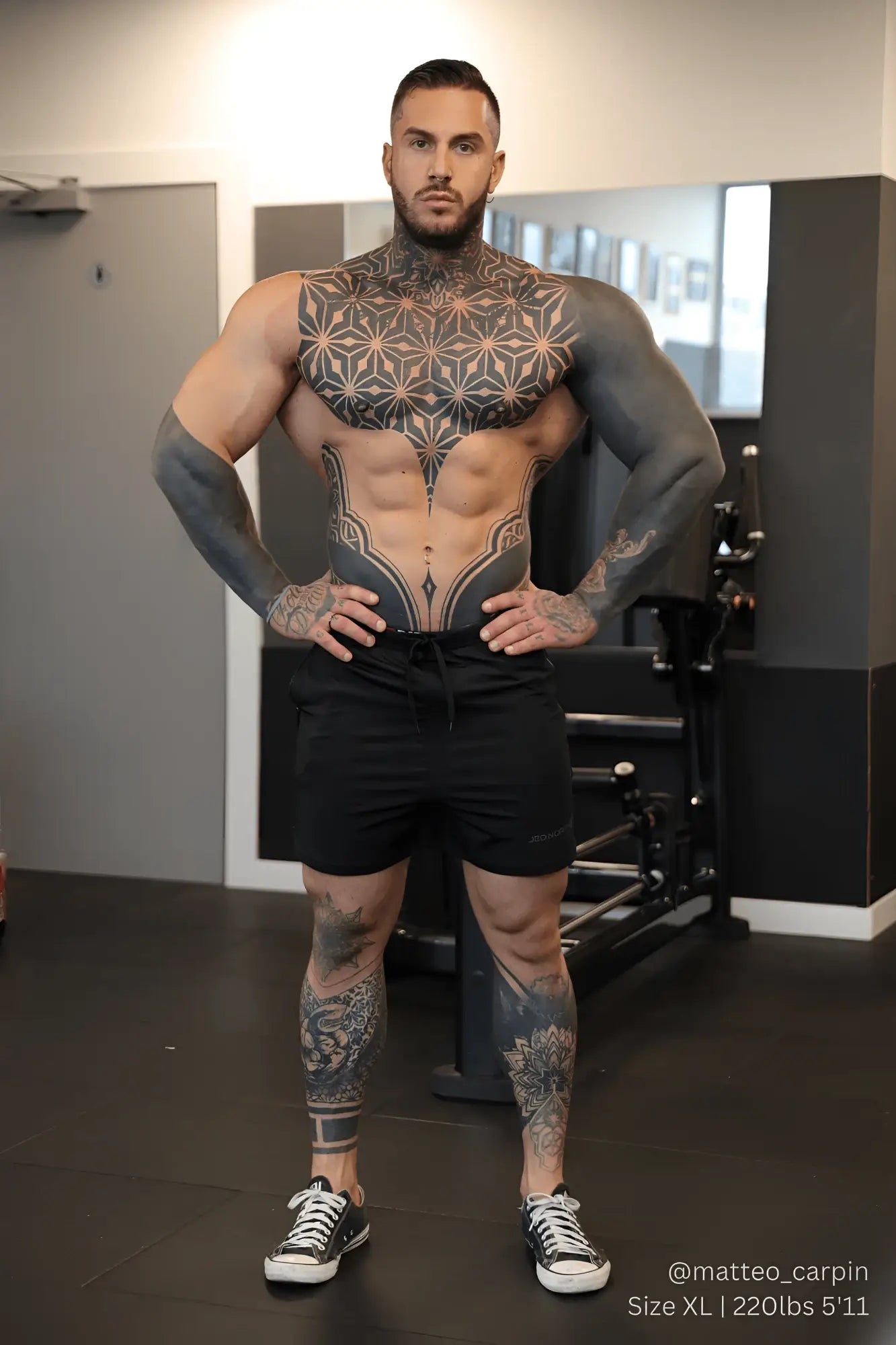 A muscular man with black and gray geometric tattoos wears Jed North Agile bodybuilding 4 inch noir shorts