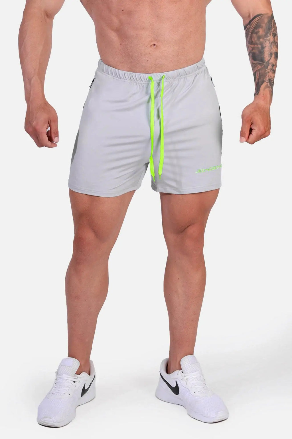 Light gray jed north agile bodybuilding 4 inch shorts with neon green drawstrings and zipper pockets in platinum gray