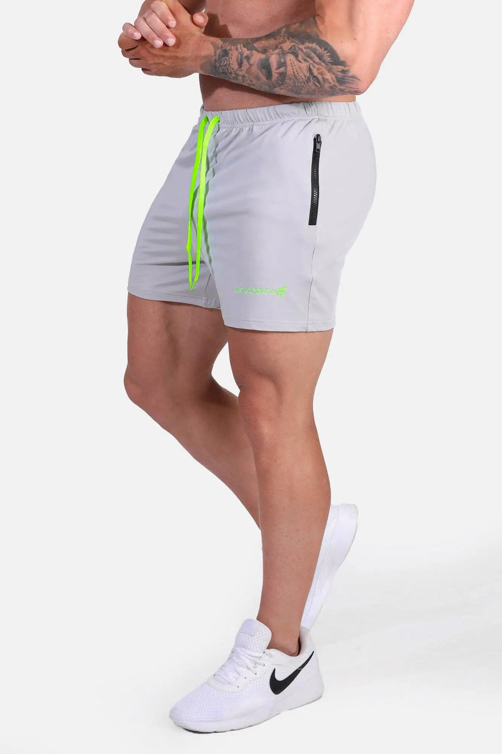 Light gray jed north agile bodybuilding 4 inch shorts with neon green drawstrings and black zipper pocket on side