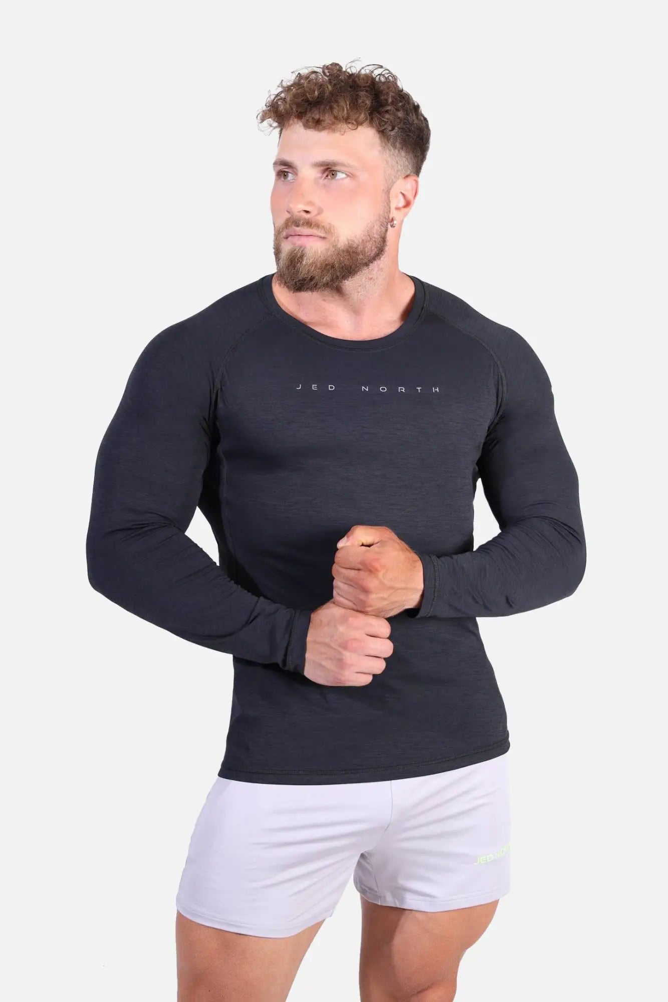 Black long-sleeve agile activewear training tee with jed north branding across the chest in charcoal black