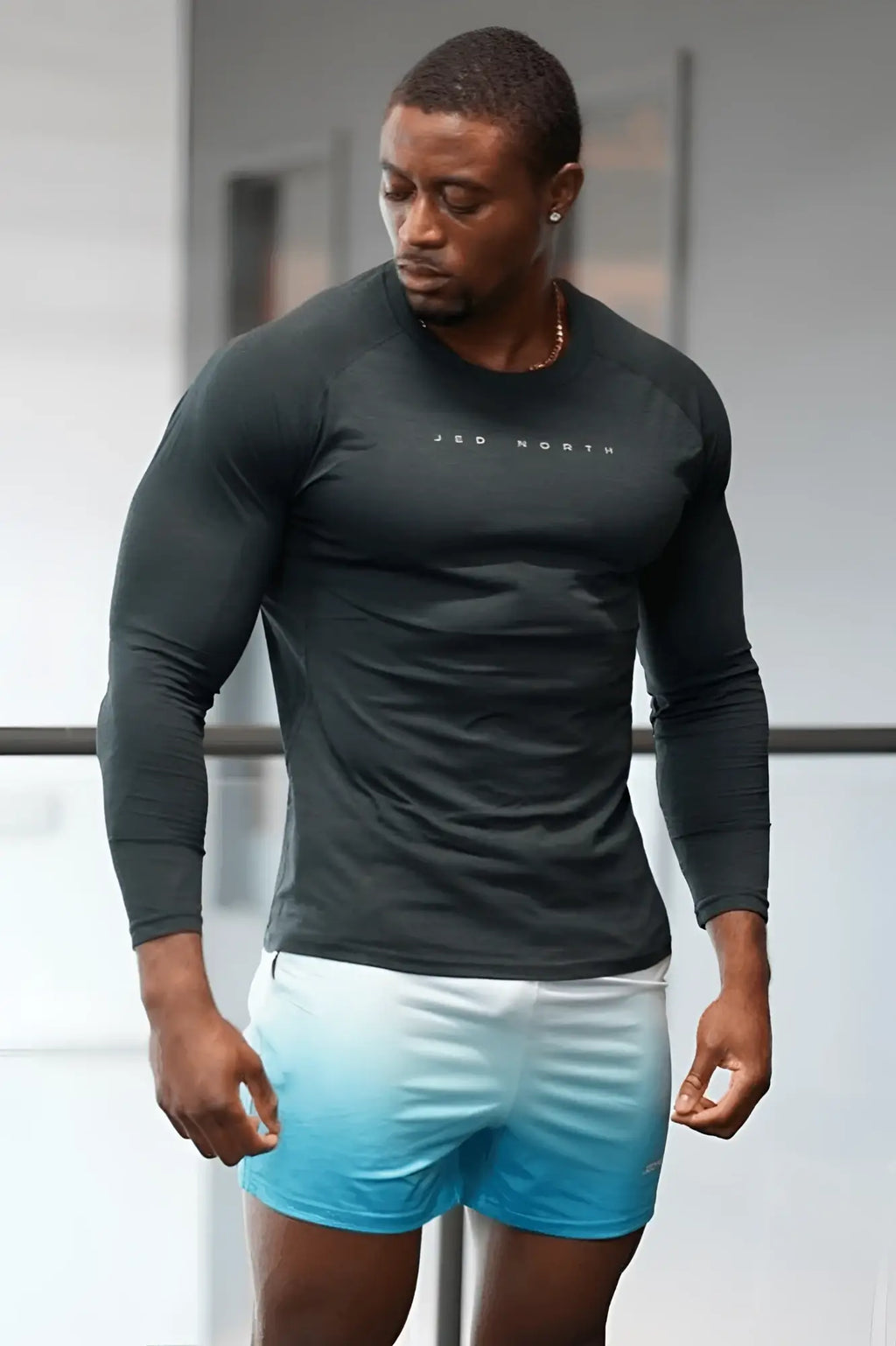 Black long sleeve athletic shirt with jed north branding across the chest for activewear training in charcoal black