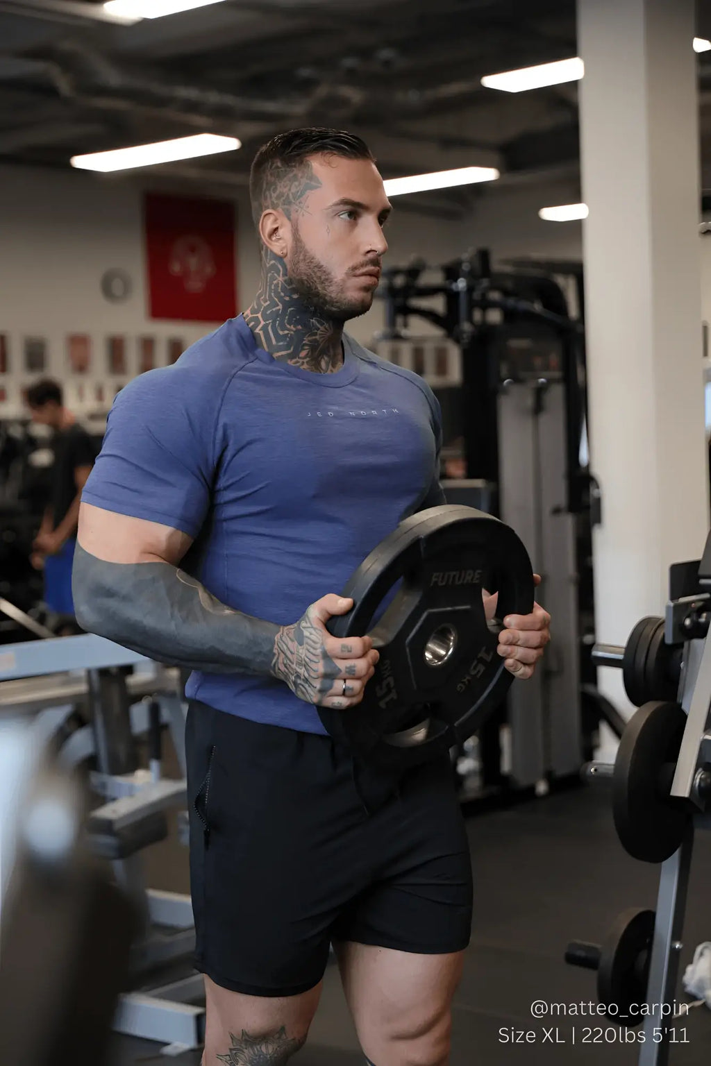 Black weight plate with aure branding and hexagonal hole paired with agile short sleeve training tee steel blue