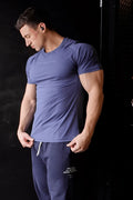 Agile short sleeve training tee in steel blue with subtle textured fabric and minimalistic white chest lettering