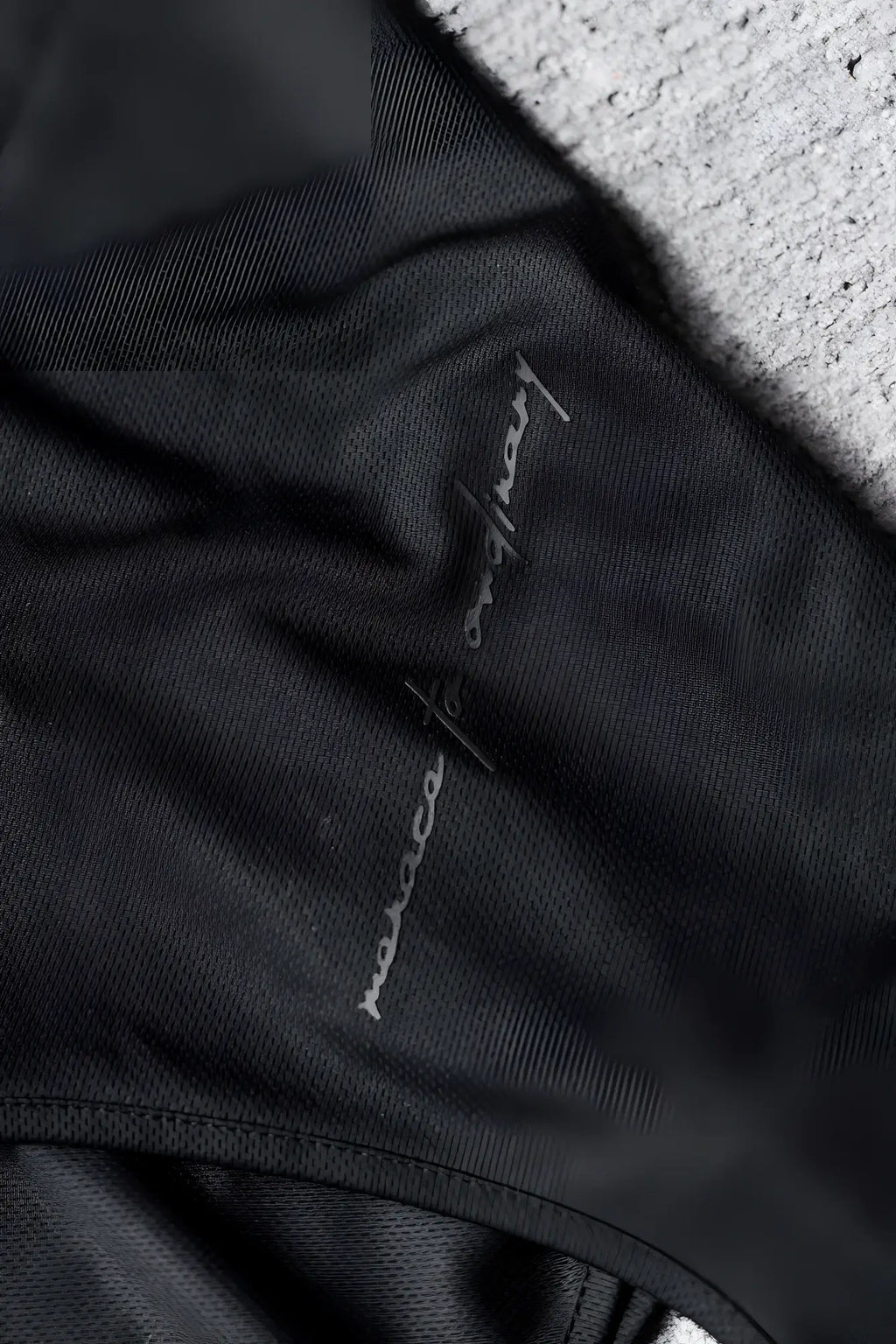 Black fabric with a subtle silver embroidered logo on the jed north alpha microfiber fast-dry gym tank top obsidian black