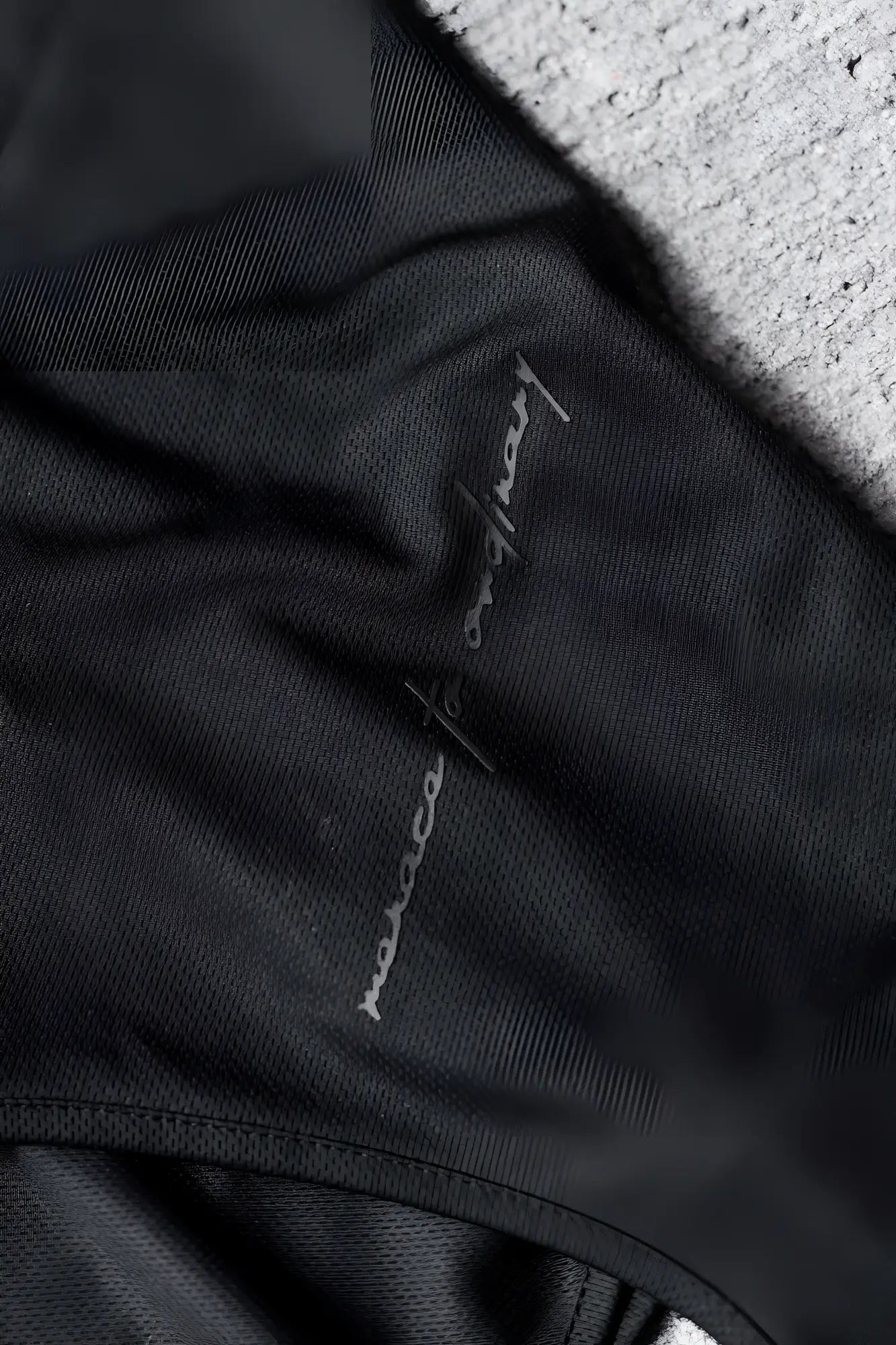 Black fabric with a subtle silver embroidered logo on the jed north alpha microfiber fast-dry gym tank top obsidian black