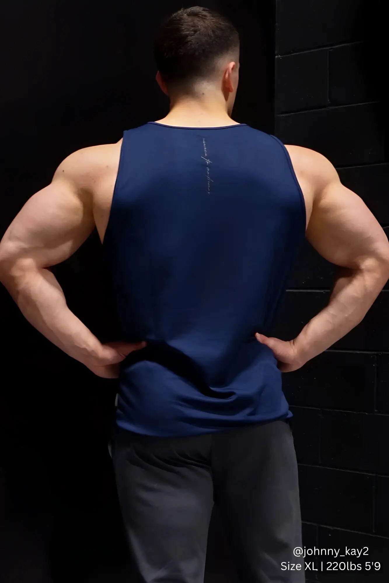 Navy blue sleeveless Jed North alpha microfiber fast-dry gym tank top showing subtle vertical logo on the back