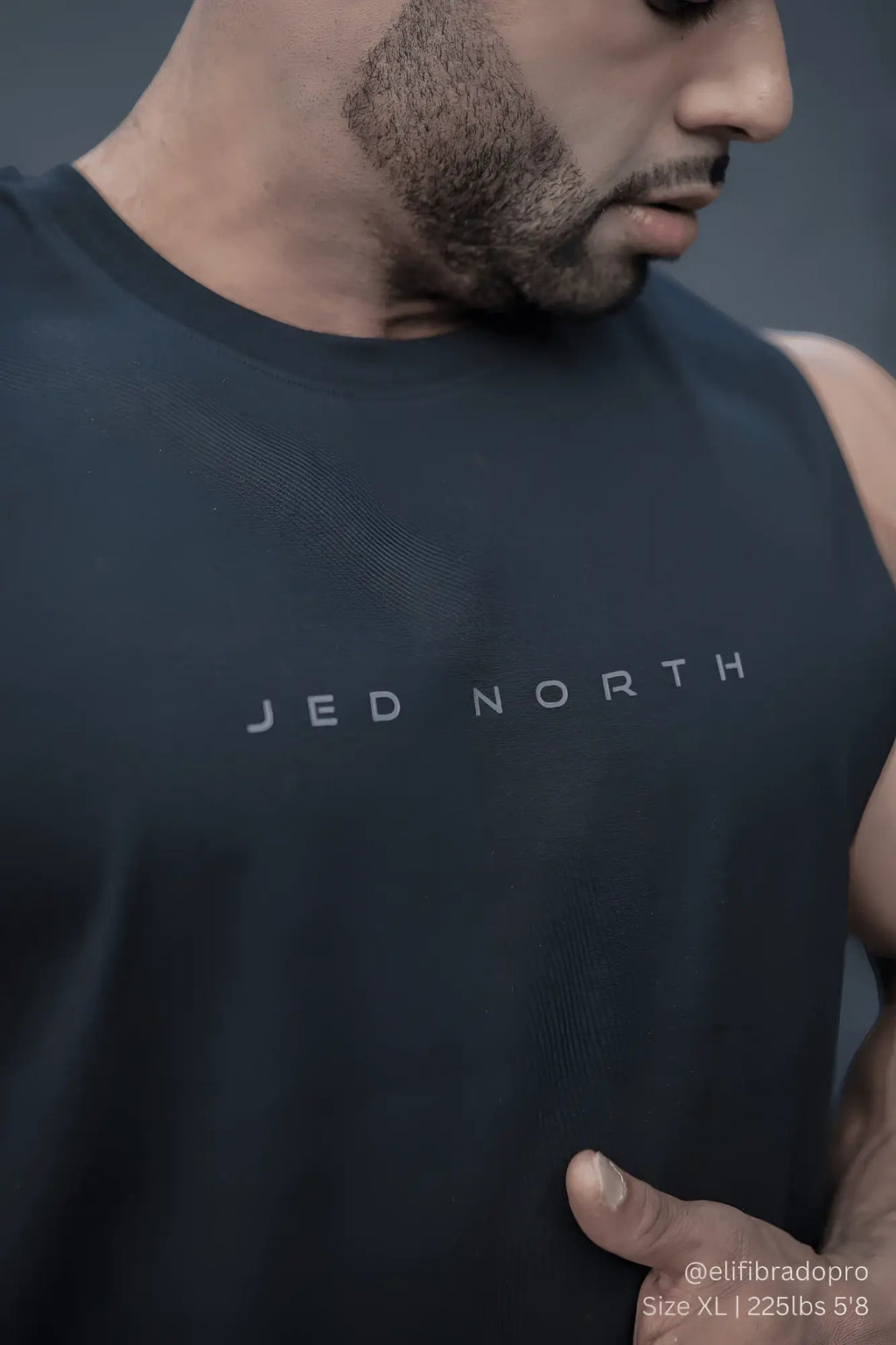 Dark gray sleeveless athletic top with jed north printed across the chest in light gray for men’s training use