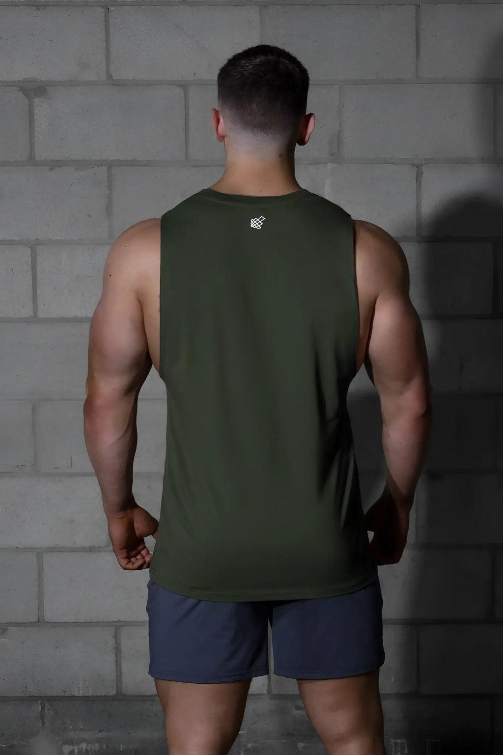 Olive green sleeveless athletic tank top by jed north with a small white logo at the neckline ideal for training